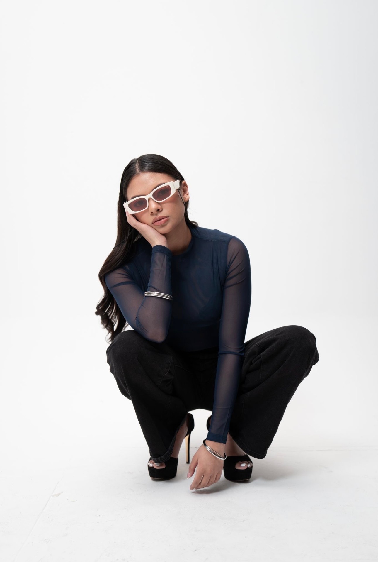 Customer in white rectangular designer sunglasses with navy mesh top